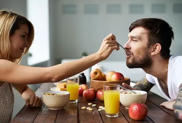 een vrouw voedt een man met noten om de potentie te vergroten